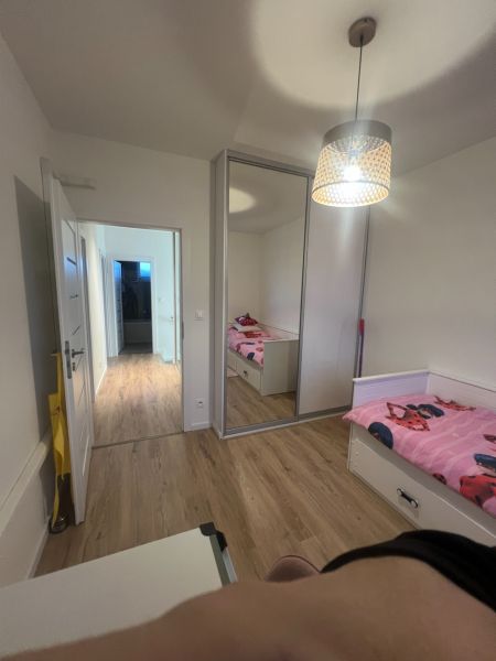 Rodinný dom - Alej Martina Benku - Kostolište  - Izba v rodinnom dome s podlahou s dreveným dekorom a zrkadlovou skriňou.