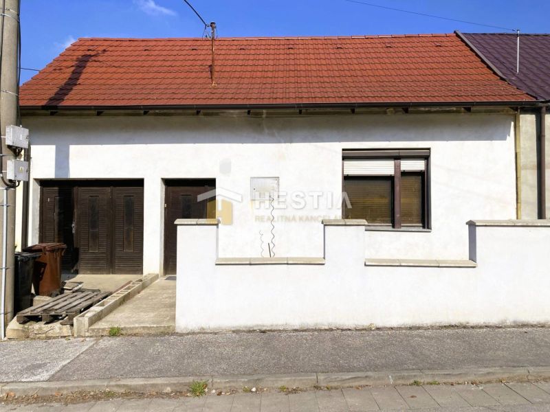 NA PREDAJ 3-izb. rodinný dom, slnečný pozemok, Senica – Kunov - Rodinný dom v Senici s tehlovou strechou, garážou a bielou fasádou.