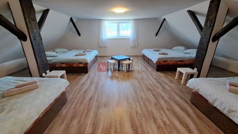 Predaj: 3 izbový rodinný dom - Partizánska Ľupča, - Podkrovná izba v rodinnom dome s posteľami a podlahou s dreveným dekorom.