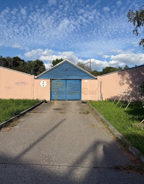 Garáž ul. Eisnerova, Devínska Nová Ves - Garáže na Eisnerovej ulici v Bratislave - Devínskej Novej Vsi, s modrou bránou a graffiti.