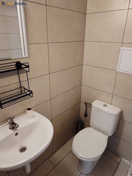 Väčší 1 izbový byt na prenájom v Komárne - Kúpeľňa v 1-izbovom byte s WC, umývadlom a svetlou dlažbou.