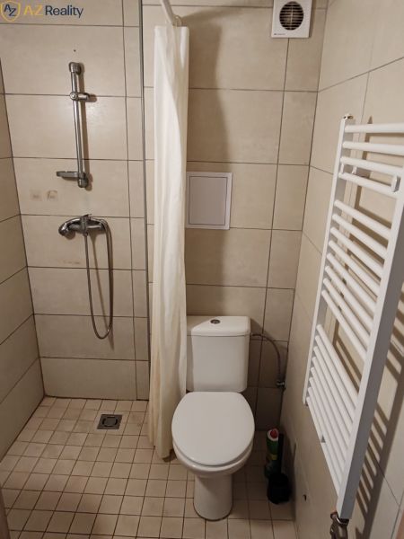 Na prenájom 1 izbový byt v Komárne - Kúpeľňa v 1-izbovom byte s toaletou, sprchou a rebríkovým radiátorom.