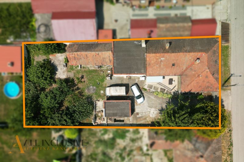 Na predaj 5-izb.rd vhodný na dvojgen. býv., Topoľníky - Letecký pohľad na rodinný dom v Topoľníkoch s autom a zeleňou na pozemku.