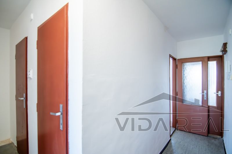 Priestranný 3-izbový byt | 72 m² + 9 m² loggia + 9 m² pivnica |  - Chodba s bielymi stenami a drevenými dverami v 3-izbovom byte.