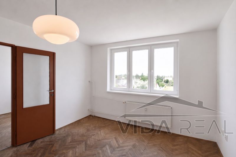 Priestranný 3-izbový byt | 72 m² + 9 m² loggia + 9 m² pivnica |  - Izba so svietidlom a podlahou s dreveným dekorom v 3-izbovom byte.
