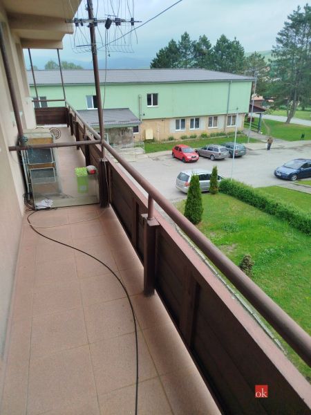 Garsónka - Balkón garsónky na Na Rovni v Ľubotíne s výhľadom na parkovisko a zeleň.