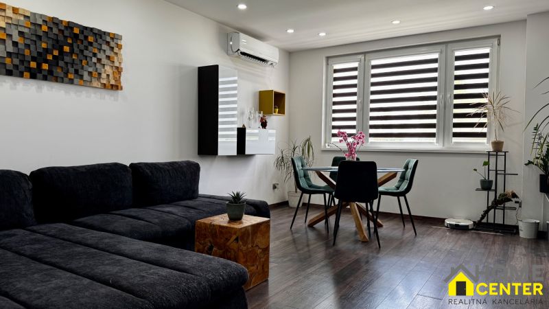 3-izbový byt | 79 m² | Komárno – sídlisko gen. Klapku - Obývacia izba s podlahou s dreveným dekorom a nábytkom v 3-izbovom byte.