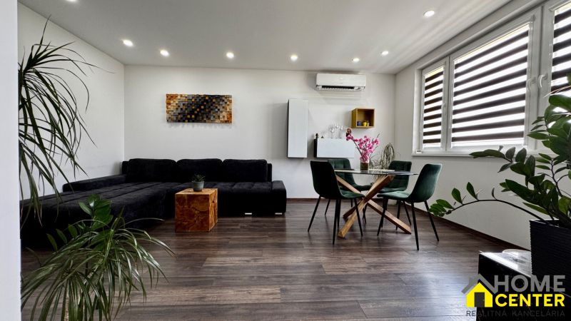 3-izbový byt | 79 m² | Komárno – sídlisko gen. Klapku - Obývačka 3-izbového bytu s nábytkom, podlahou s dreveným dekorom a izbovými rastlinami.