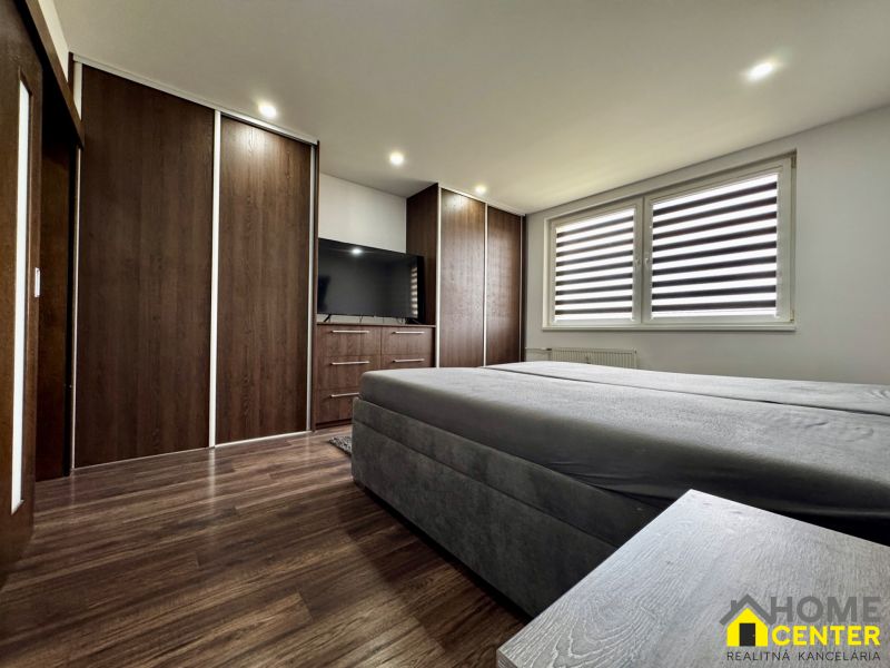 3-izbový byt | 79 m² | Komárno – sídlisko gen. Klapku - Spálňa v 3-izbovom byte s veľkým šatníkom a televízorom, podlaha s dreveným dekorom.