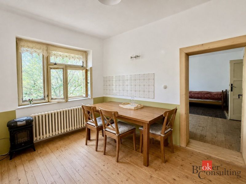 Vidiecky rodinný dom na polosamote, krása a pokoj na jednom mieste - Izba v rodinnom dome s kreslom a dekoratívnou dlažbou.