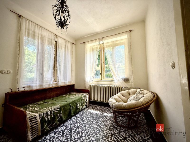 Vidiecky rodinný dom na polosamote, krása a pokoj na jednom mieste - Spálňa v rodinnom dome s podlahou s dreveným dekorom, svetlý interiér, béžové kreslá.