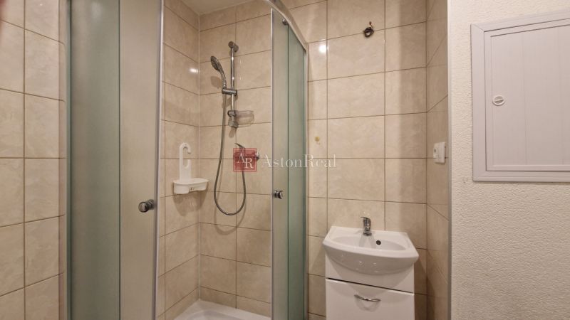AstonReal: na predaj 2-izbový byt 54 m2 - Poprad, Komenského - Kúpeľňa so sprchovacím kútom a umývadlom v 2-izbovom byte, obkladané steny.