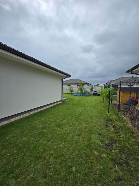 Predaj 4 izbového rodinného domu, pozemok od 523 m2,  NOVOSTAVBA 2023 - Záhrada vedľa rodinného domu na Ipeľskej ulici v Bernolákove s oplotením a trávnikom.