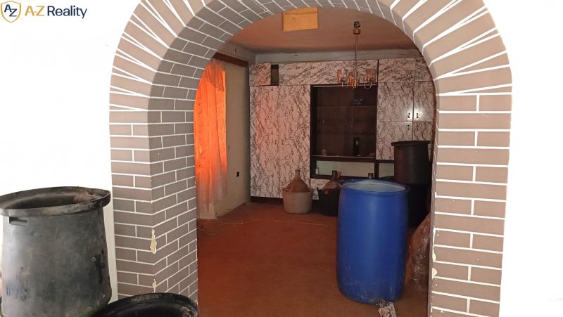 Na predaj starší rodinný dom s podkrovím v obci Gbelce - Interiér rodinného domu s tehlovým oblúkom a veľkými plastovými nádobami.
