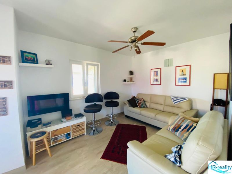Brač(HR)- zariadený apartmán s výhľadom na more - Obývacia izba v rekreačnom apartmáne s pohovkami a podlahou s dreveným dekorom.