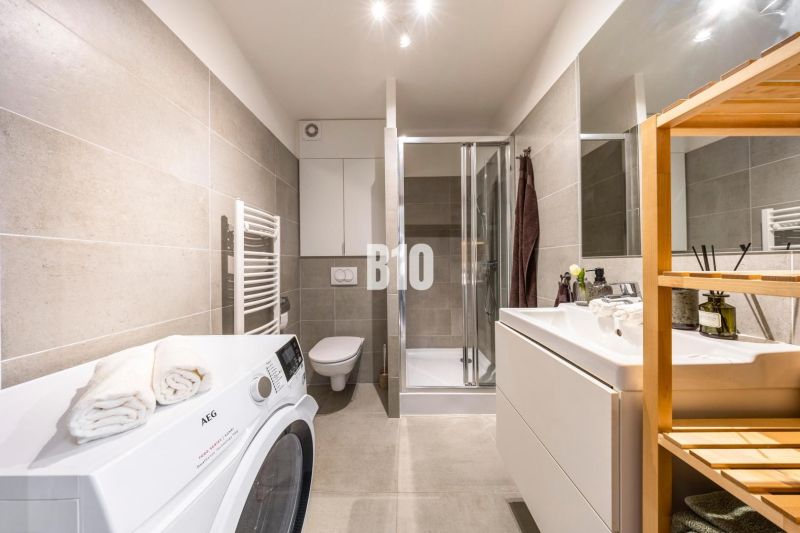 VILA ĽADOVÁ | MODERNÝ 2IZBOVÝ BYT V KOMORNOM PROJEKTE PRI RAČIANSKOM M - Kúpeľňa v 2-izbovom byte s práčkou, sprchovacím kútom, umývadlom a toaletou.