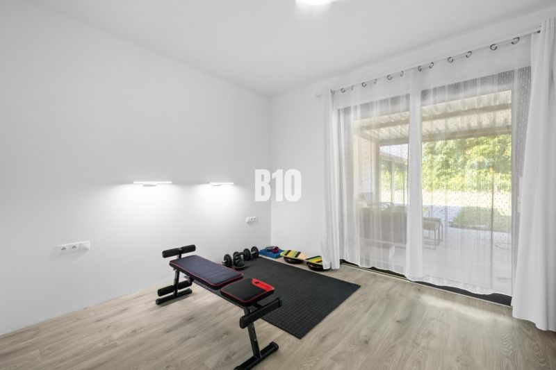 1 255 m² a 9 izieb I Priamo pri prírodnej rezervácii Šúr, len 15 minút - Posilňovňa v rodinnom dome s činkami, lavicou a podlahou s dreveným dekorom.