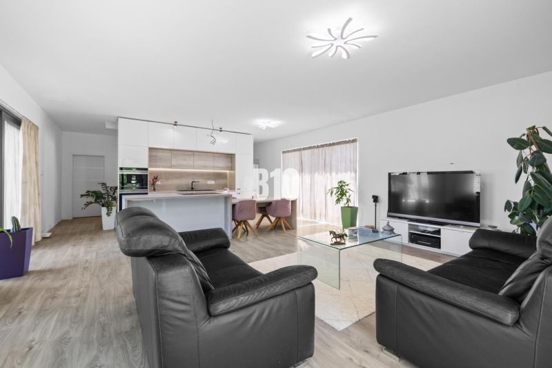 1 255 m² a 9 izieb I Priamo pri prírodnej rezervácii Šúr, len 15 minút - Obývacia izba s čiernou koženou sedačkou, kuchynským ostrovčekom a podlahou s dreveným dekorom.