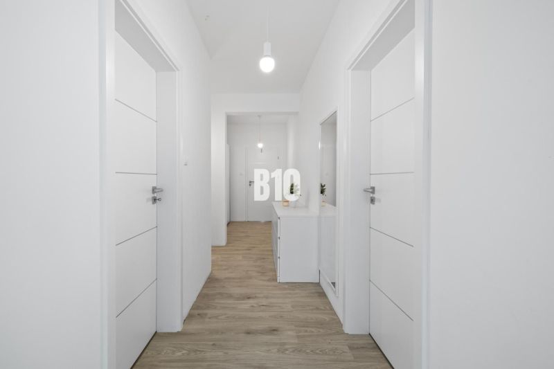1 255 m² a 9 izieb I Priamo pri prírodnej rezervácii Šúr, len 15 minút - Biela chodba s podlahou s dreveným dekorom v rodinnom dome, vybavená svetlom a zrkadlom.