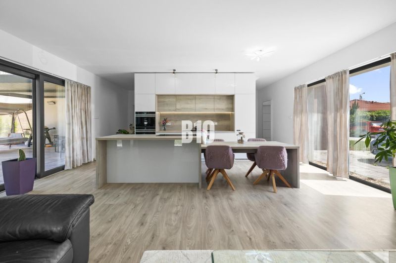 1 255 m² a 9 izieb I Priamo pri prírodnej rezervácii Šúr, len 15 minút - Kuchyňa v rodinnom dome s ostrovčekom, podlahou s dreveným dekorom a veľkými oknami.