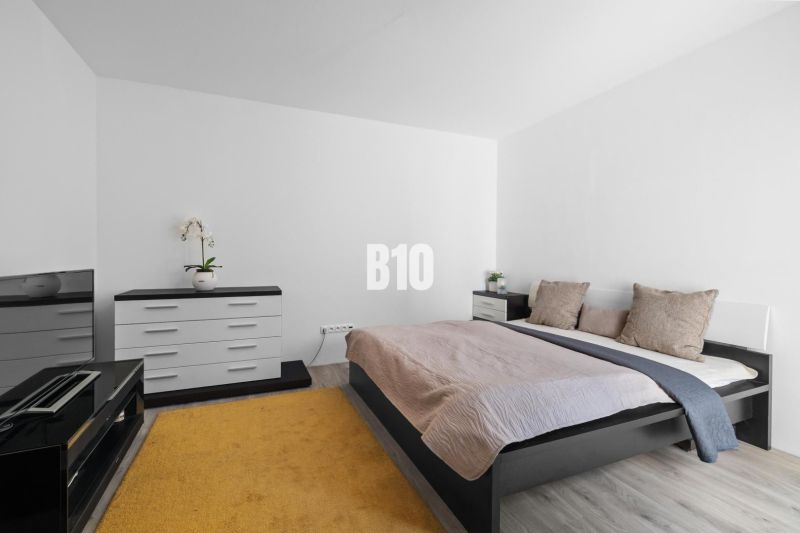 1 255 m² a 9 izieb I Priamo pri prírodnej rezervácii Šúr, len 15 minút - Spálňa s posteľou, komodou a podlahou s dreveným dekorom v rodinnom dome.