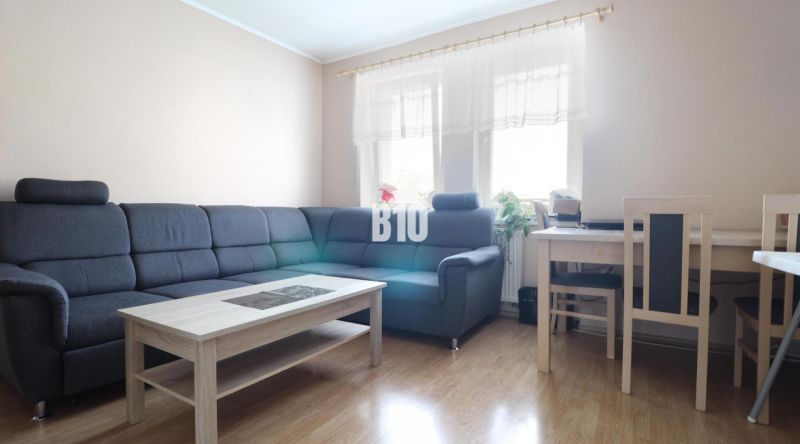 3 izbový byt Vrútky výhodná cena - Obývacia izba v 3-izbovom byte s rohovou sedačkou a dreveným dekorom podlahy.