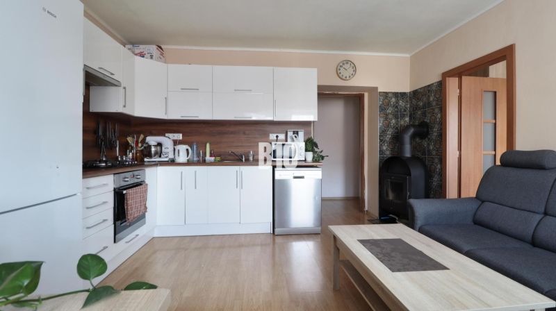 3 izbový byt Vrútky výhodná cena - Svetlá kuchyňa s bielymi skrinkami a podlahou s dreveným dekorom v 3-izbovom byte.