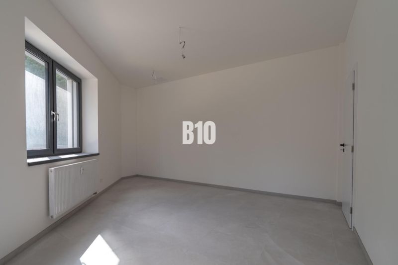 ADMINISTRATÍVNY PRIESTOR (127,87 m²) V NOVOSTAVBE REZIDENCIA KUBÍN V C - Kancelárie s bielymi stenami, veľkým oknom a svetlou podlahou s dreveným dekorom.
