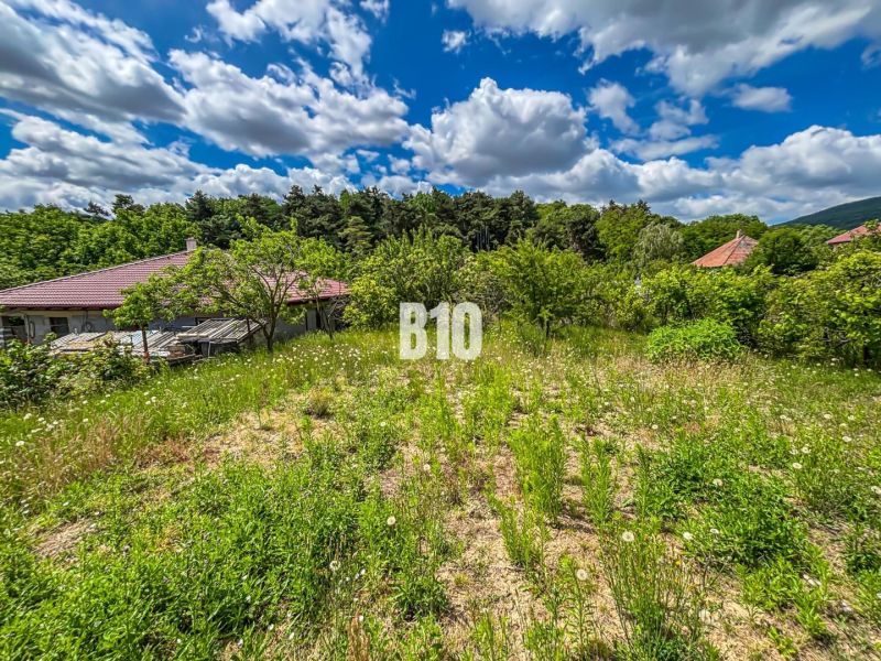 Stavebný pozemok 750 m² v Kolíňanoch – pokojné bývanie v príjemnom pro - Pozemky - bývanie v Kolíňanoch so zeleňou, okolité domy a čiastočne zamračená obloha.