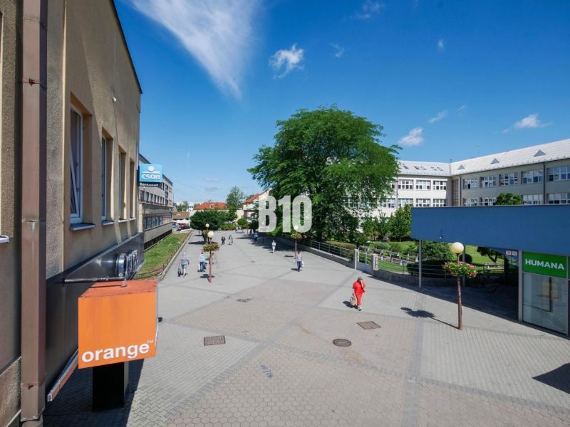 Obchodné priestory s charakterom v srdci Topoľčian – investícia, ktorá - Obchodné priestory na Obchodnej ulici v Topoľčanoch, pešia zóna s ľuďmi a budovami.