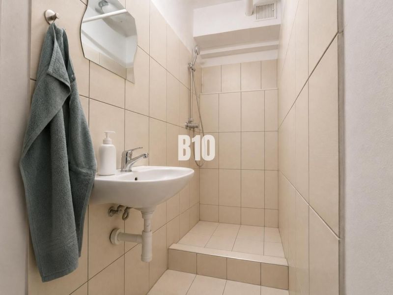2-izbový byt po rekonštrukcii za dostupnú cenu!!! - Kúpeľňa s umývadlom, sprchovým kútom a béžovým obkladom v 2-izbovom byte.
