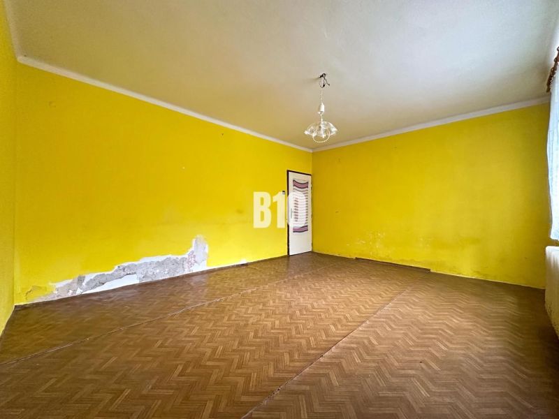 Rodinný dom s potenciálom v pokojnej lokalite – Nové Nosice, Púchov - Izba s podlahou s dreveným dekorom a žltými stenami v rodinnom dome.