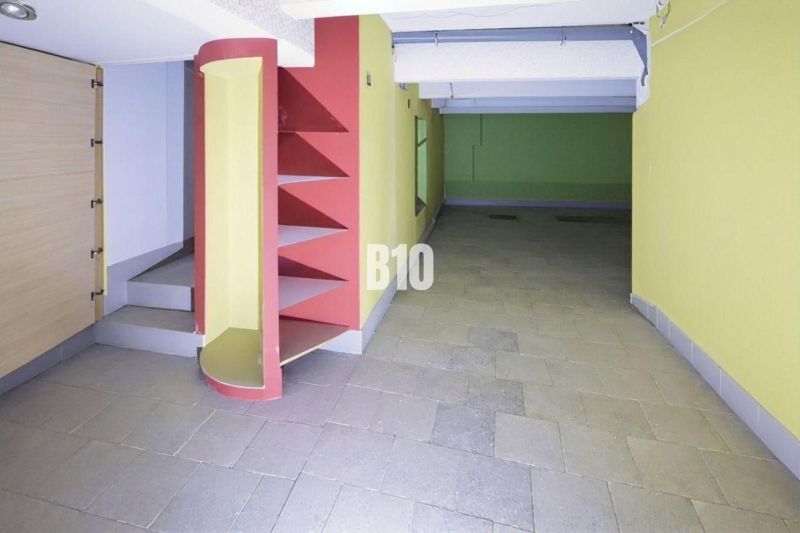 PRENÁJOM: Obchodný priestor 111m2 v centre Čadce - Farebné obchodné priestory s policami a dlažbou, vhodné pre rôzne využitie.