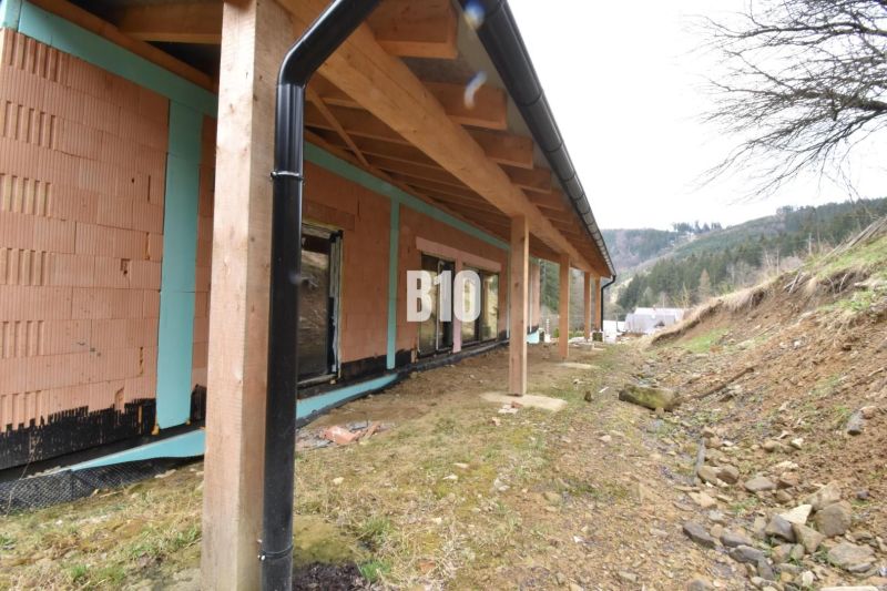 Novostavba rodinného domu - Horná Mariková, Trenčiansky kraj - Stavba rodinného domu v Považskej Bystrici, drevená terasa a hory v pozadí.