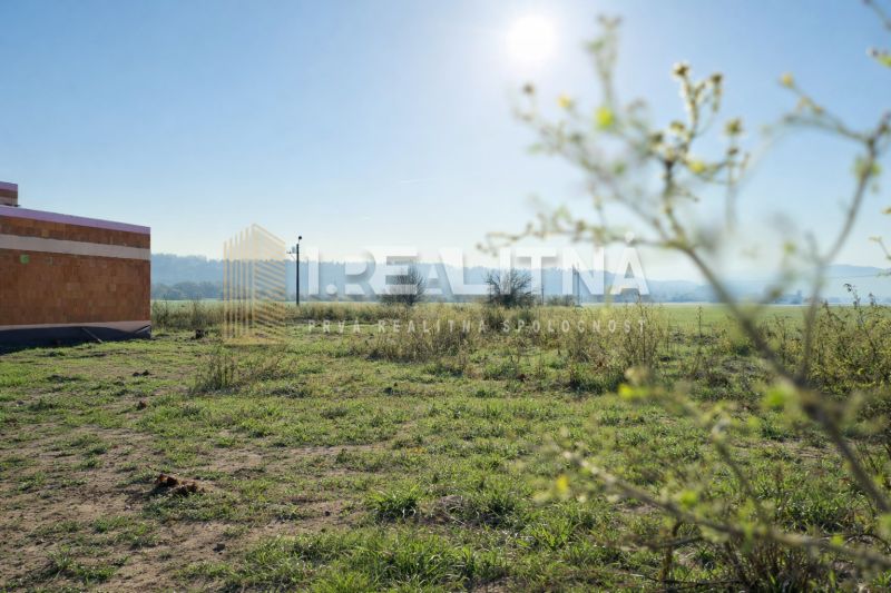 STAVEBNÝ POZEMOK NA SLIAČI, 861M2, SLNEČNICA - Pozemky - bývanie na Slnečnicovej ulici v Sliači s trávnatou plochou a stavbou.