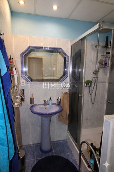 NA PREDAJ - 3 izbový byt na Sídlisku III. v meste Humenné - Kúpeľňa v 3-izbovom byte, obsahujúca sprchový kút a umývadlo s modrými detailmi.