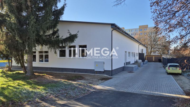 PREDAJ OBCHODNÉHO PRIESTORU v HUMENNOM (sídlisko 2A) - Budova obchodných priestorov na Tyršovej ulici v Humennom obklopená stromami.
