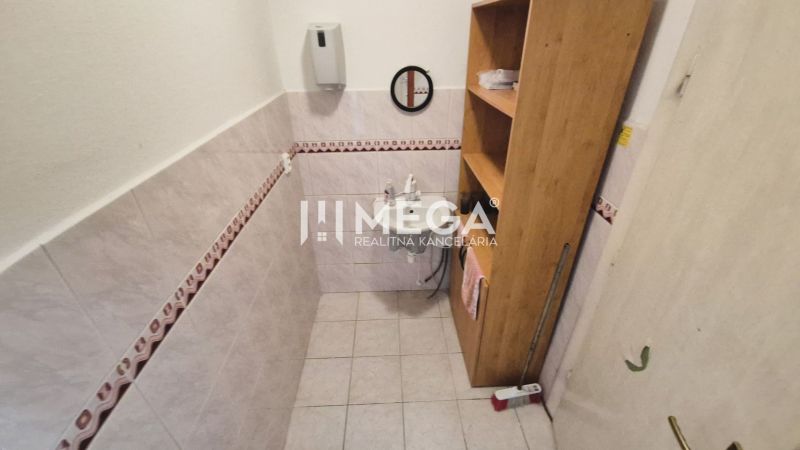 PRENÁJOM OBCHODNÉHO PRIESTORU PRIAMO V CENTRE HUMENNÉHO - Kúpeľňa v obchodných priestoroch s umývadlom, poličkami a dlažbou na stenách.