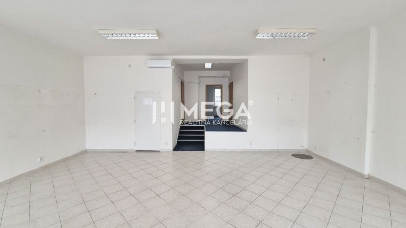 PRENÁJOM OBCHODNÉHO PRIESTORU PRIAMO V CENTRE HUMENNÉHO - Obchodné priestory s bielymi stenami a dlažbou, schody vedú do vyššej úrovne.