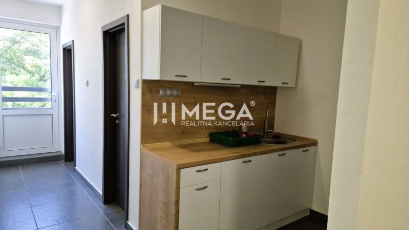 PRENÁJOM kancelárie blízko centra Humenného (15,20 m2) - Kuchynský kút v kancelárii s dreveným dekorom a veľkým oknom.