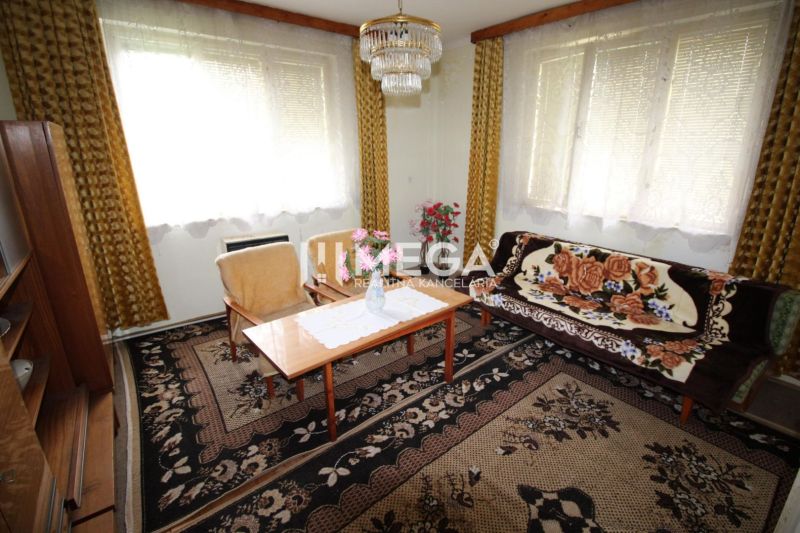 REZERVOVANÝ - Pôvodný rodinný dom v obci Dlhé nad Cirochou - Obývačka v rodinnom dome s kobercom, gaučom a lustrom.
