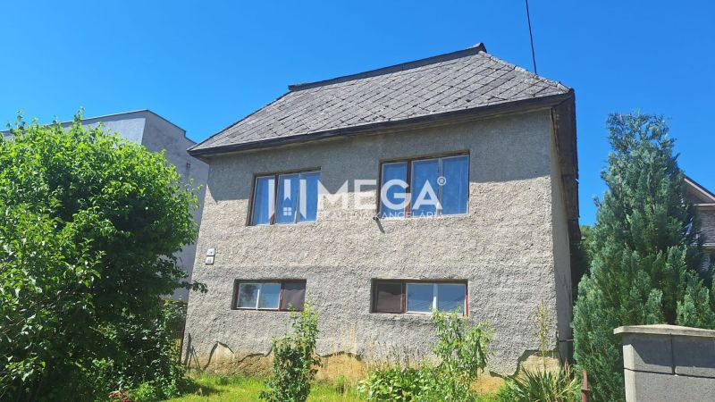 NA PREDAJ - Rodinný dom s pozemkom 3 277 m² v Snine - Rodinný dom na Jesenského ulici v Snine, obklopený zeleňou a stromami.