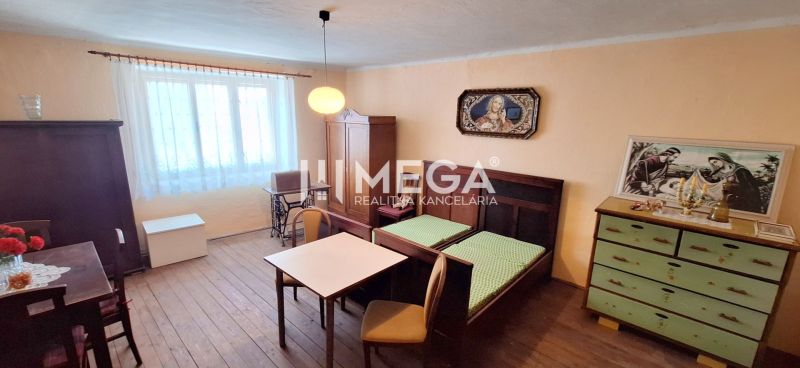 ZNÍŽENÁ CENA -  NA PREDAJ Dom v obci Kochanovce - Interiér rodinného domu s nábytkom, dreveným dekórom podlahy a obrazmi na stenách.