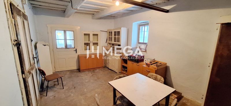 ZNÍŽENÁ CENA -  NA PREDAJ Dom v obci Kochanovce - Izba v rodinnom dome so starším nábytkom a stolom, bez dekoračnej podlahy.
