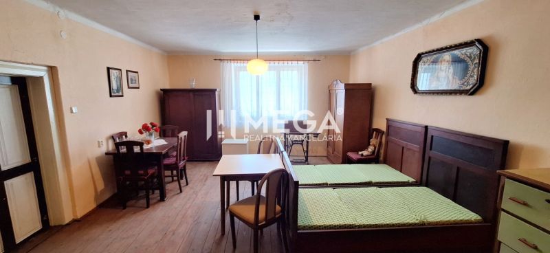 ZNÍŽENÁ CENA -  NA PREDAJ Dom v obci Kochanovce - Izba v rodinnom dome s dreveným dekorom, starožitným nábytkom a jednoduchým osvetlením.