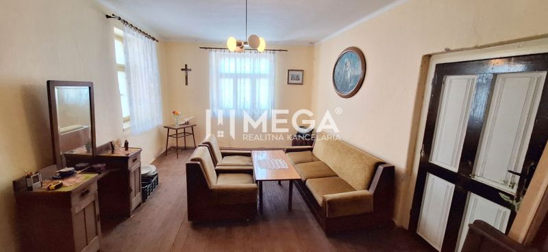 ZNÍŽENÁ CENA -  NA PREDAJ Dom v obci Kochanovce - Obývacia izba v rodinnom dome s pohovkou a dreveným dekorom podlahy.