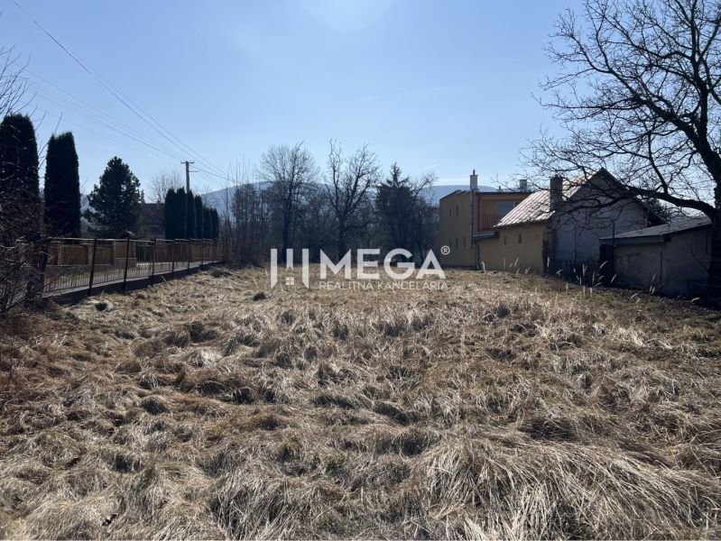 Výrazne znížená cena za stavebný  pozemok na predaj, Modrá nad Cirocho - Pozemky - bývanie v Modre nad Cirochou s trávnatou plochou a viditeľnými budovami.
