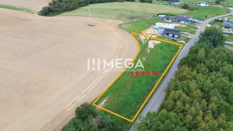 NA PREDAJ INVESTIČNÝ POZEMOK S PANORAMATICKÝM VÝHĽADOM SNINA - Pozemky na bývanie pri Hámorskej ulici v Snine, 1692 m², vedľa cesty a polí.