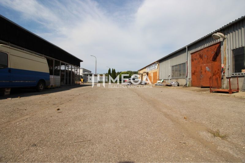 FLEXIBILNÝ PRENÁJOM HALY V HUMENNOM – od 600€ až 300 m² - Exteriér skladov a hál na Fidlikovej ulici v Humennom s parkovanými vozidlami.