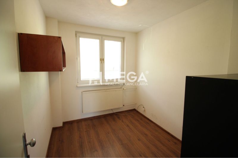 PRENÁJOM KANCELÁRII 40 m² BEZ DEPOZITU - Chemlonská HUMENNÉ - Izba v kancelárii s podlahou s dreveným dekorom, bielymi stenami a nástennou skrinkou.
